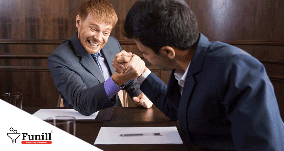 Dois homens sentados à mesa disputando uma queda de braço