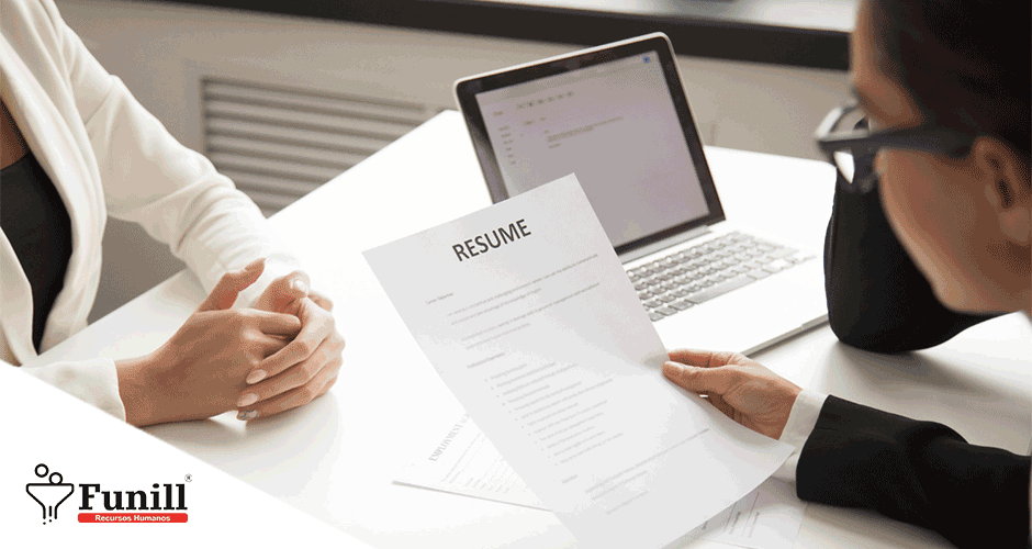 Duas mulheres sentadas à mesa com um laptop