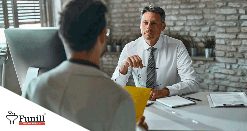 Um homem sentado em uma mesa conversando com outro homem