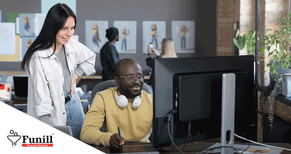 Um homem sentado em uma mesa em frente a um computador