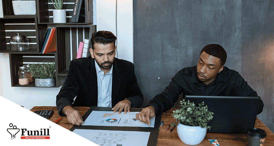 Dois homens sentados à mesa trabalhando em um projeto